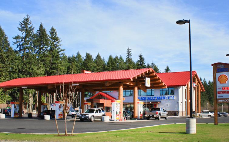 A TCSA-member convenience store in Yelm, WA, featuring a striking red canopy held up by logs.